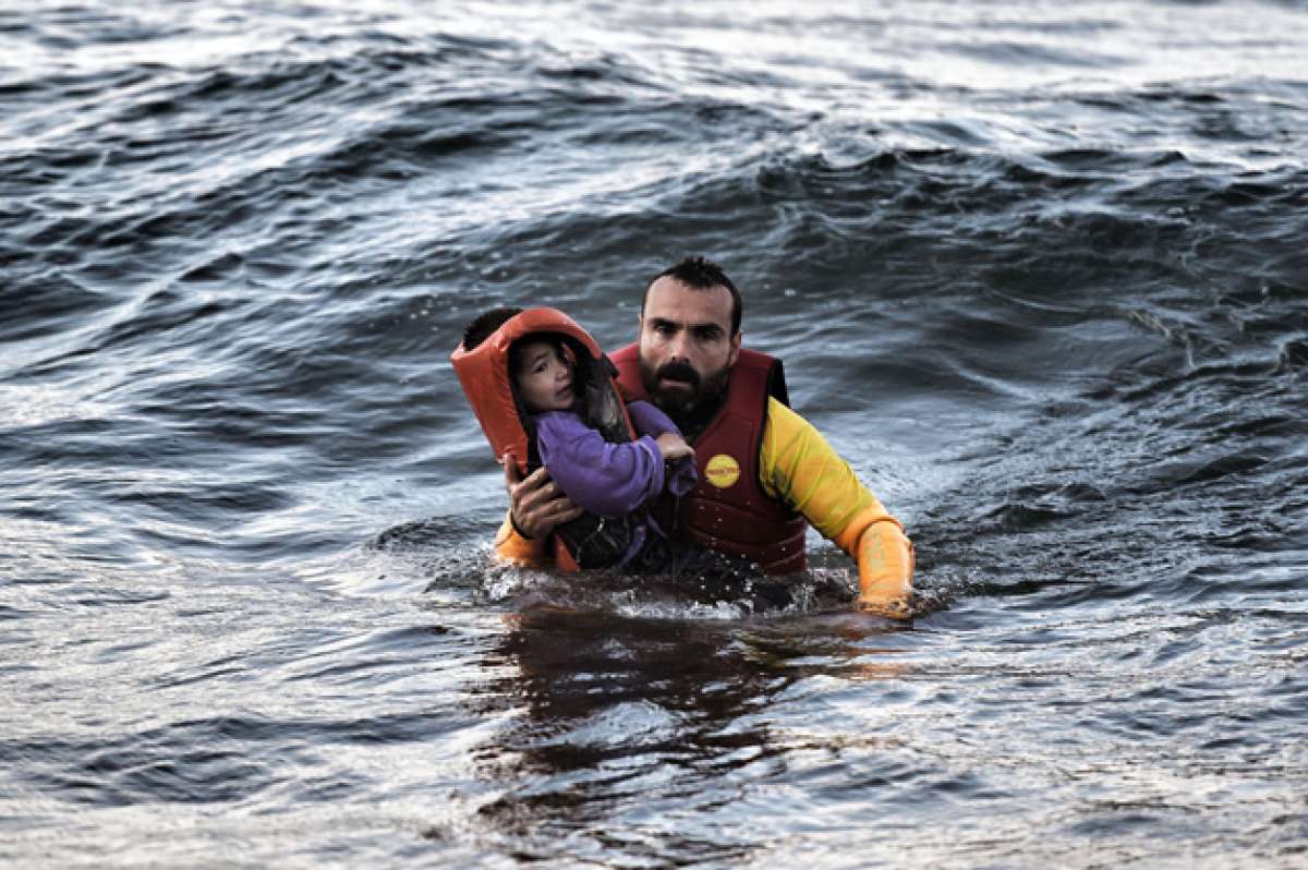 Un socorrista espa&ntilde;ol rescata a un  ni&ntilde;o que viajaba en una embarcaci&oacute;n que naufrag&oacute; al cruzar el mar Egeo desde Turqu&iacute;a. Foto: AFP