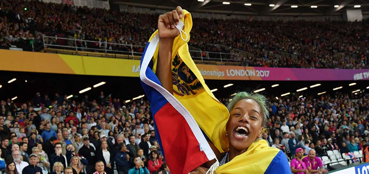 Yulimar Rojas, arropada por la bandera venezolana, festeja orgullosa el t&iacute;tulo mundial en salto triple en la pista del estadio ol&iacute;mpico de Londres.