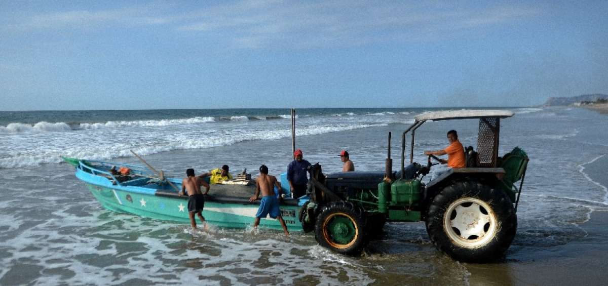 Con su tractor, Eloy empuja las fibras al mar. Por ese trabajo cobra $  40 a la semana por embarcaci&oacute;n.