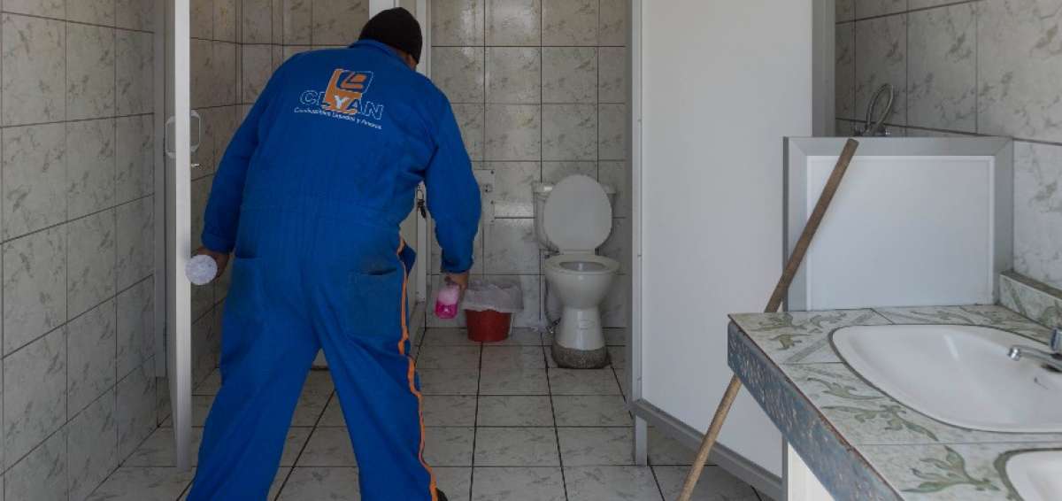 Personal de limpieza realiza el mantenimiento en una gasolinera en Quito.