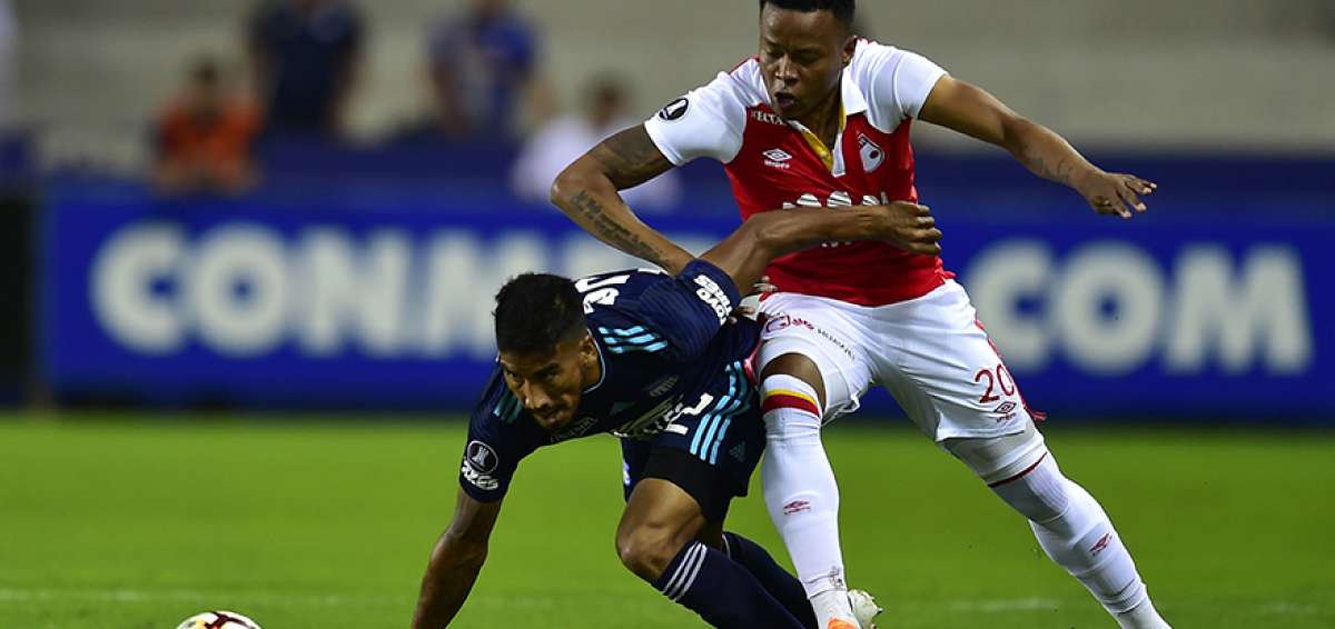 El volante Fernando Luna (izq.), de Emelec, disputa el bal&oacute;n con John Pajoy, autor de uno de los goles del Santa Fe.