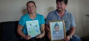 Carlos Cede&ntilde;o Ay&oacute;n (der.) y su esposa Tania V&eacute;liz posan en la sala de su casa de campo -en la zona rural de San Vicente- con las fotograf&iacute;as que guardan de Carlitos.