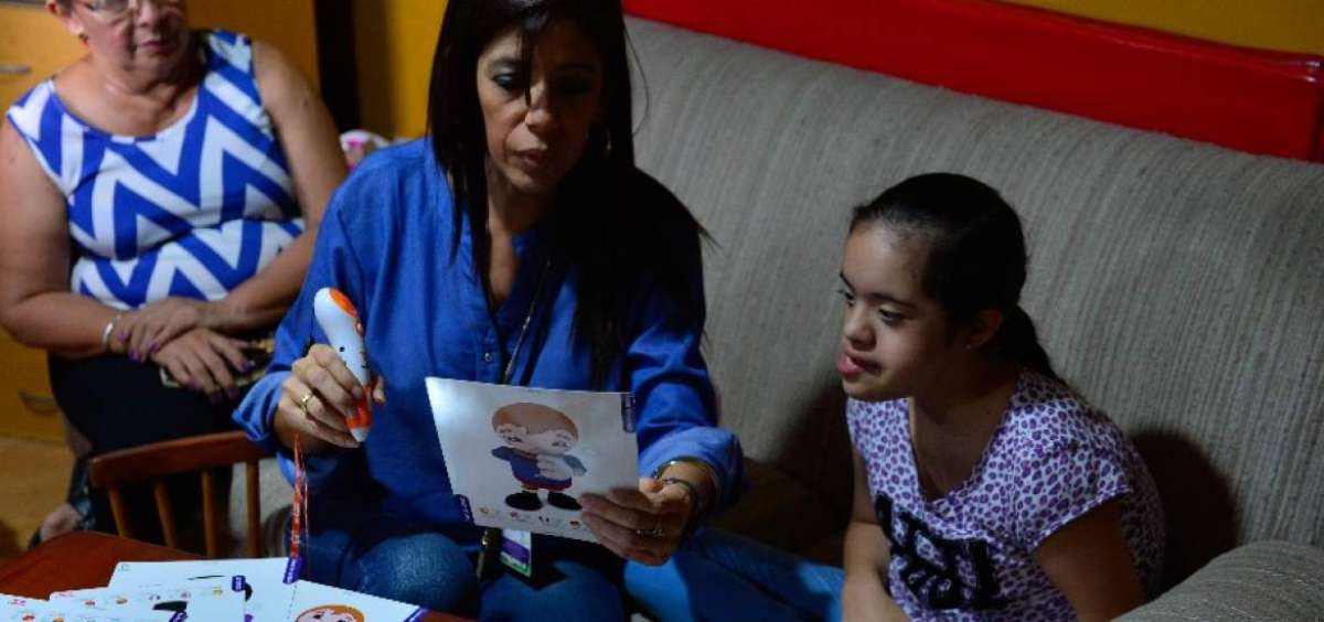 En uno de los salones de la fundaci&oacute;n, los menores reciben las clases con videos multiling&uuml;es.
