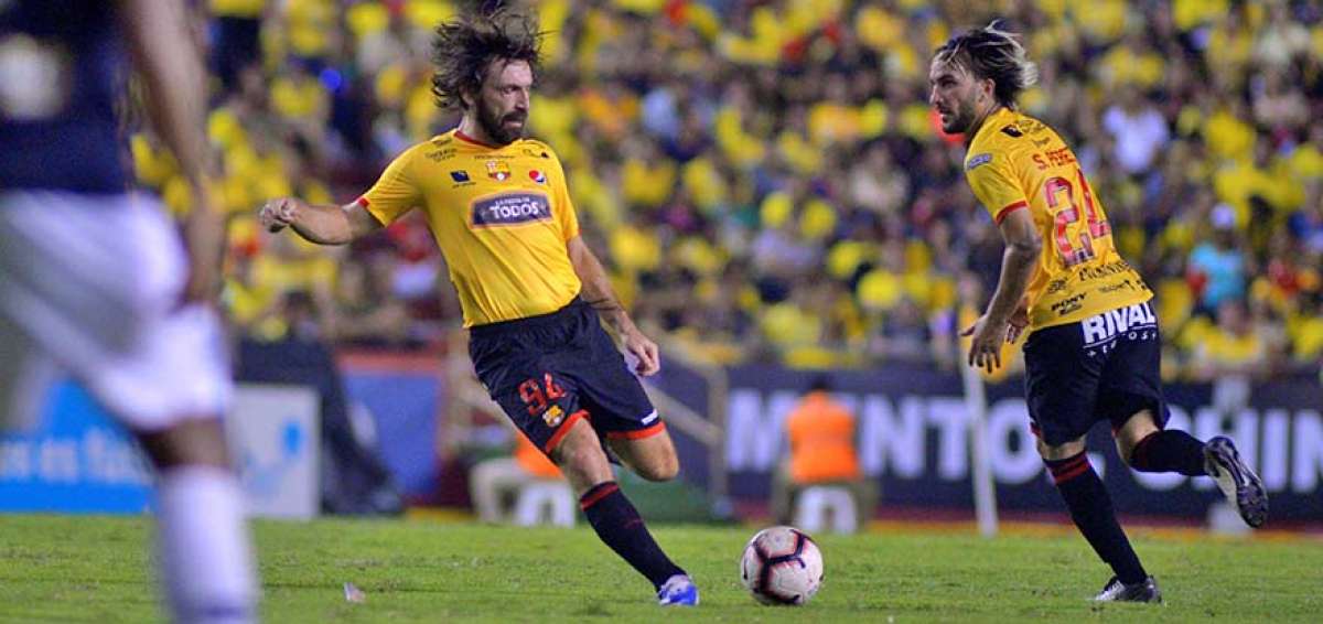 Andrea Pirlo (izq.) patea el bal&oacute;n ante la atenta mirada de Sebasti&aacute;n P&eacute;rez (der.). Ambos jugadores hicieron pareja en la primera zona de volantes en el partido de presentaci&oacute;n de Barcelona.
