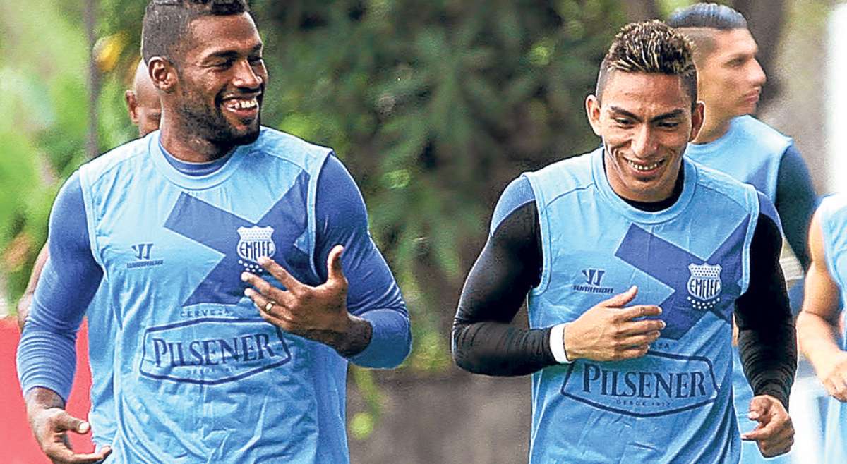 El defensa Gabriel Achilier (izq.) y &Aacute;ngel Mena dialogan durante una de las &uacute;ltimas pr&aacute;cticas que realiz&oacute; Emelec en el complejo Los Samanes, en Guayaquil. Foto: Tomado de Andes