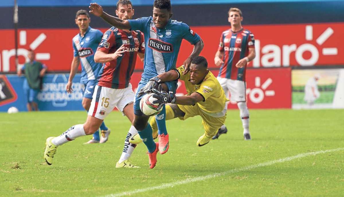 El arquero de Deportivo Quito, Alexis Lemos, intercepta la pelota ante una arremetida del defensa de Emelec Fernando Pinillo. Foto: Miguel Castro / El Tel&eacute;grafo
