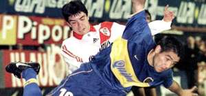Javier Saviola (i) de River Plate disputando un bal&oacute;n con Juan Rom&aacute;n Riquelme (d) de Boca Juniors durante un partido de cuartos de final de la Copa Libertadores en el estadio La Bombonera en Buenos Aires en el 2000.