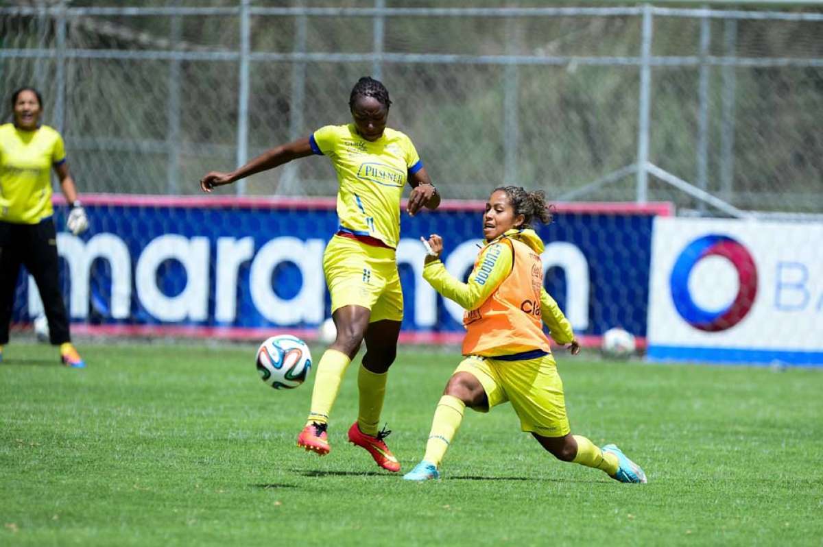 La delantera de la Selecci&oacute;n Carina Caicedo (izq.) disputa el bal&oacute;n con la volante Andrea Pesantes, durante una pr&aacute;ctica en la Casa de la Selecci&oacute;n. Foto: &Aacute;lvaro P&eacute;rez.