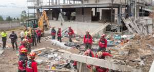 Rescatistas del Cuerpo de Bomberos buscan entre los escombros del muro colapsado los restos del obrero fallecido a consecuencia del suceso.