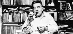 Lezama enciende un habano en su biblioteca.