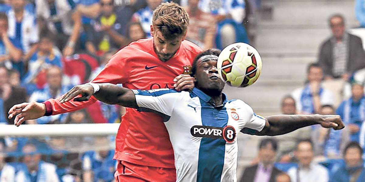 El ecuatoriano Felipe Caicedo (der.) disputa un bal&oacute;n con el defensa del Barcelona, Gerard Piqu&eacute;, durante el derbi catal&aacute;n. Foto: AFP