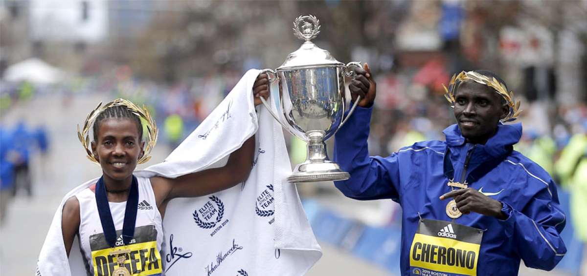 La et&iacute;ope Worknesh Degefa y el keniano Lawrence Cherono posan con las medallas y el trofeo durante la premiaci&oacute;n de la Marat&oacute;n de Boston.
