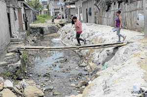 Los moradores improvisaron cinco puentes de madera para poder cruzar la abertura, que tiene casi 20 a&ntilde;os, en el populoso sector.