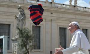 Un fiel cat&oacute;lico le arroja al Sumo Pont&iacute;fice una camiseta del club de San Lorenzo, equipo del cual es hincha el papa argentino. FOTO: AFP