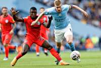 Moisés Caicedo (izq.) procura frenar al belga Kevin de Bruyne