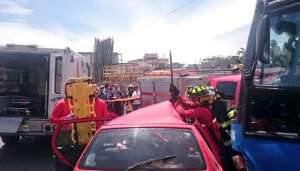 Miembros del Cuerpo de Bomberos realizan el rescate de los ocupantes de un veh&iacute;culo que fue impactado por un bus. Foto: tomada del Twitter del la AMT