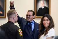 Johnny Depp levanta su mano en señal de triunfo, tras el último día del juicio