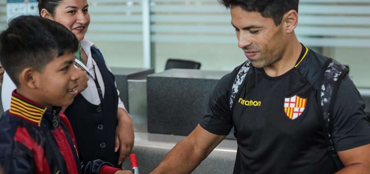 Mat&iacute;as Oyola (der.), capit&aacute;n de Barcelona, firma un aut&oacute;grafo a un hincha del equipo que fue a despedirlos al aeropuerto de Guayaquil.