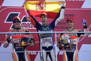 El espa&ntilde;ol Jorge Lorenzo (c) se impuso en el GP de Valencia y levant&oacute; su tercer trofeo mundial de Motociclismo. Foto: AFP