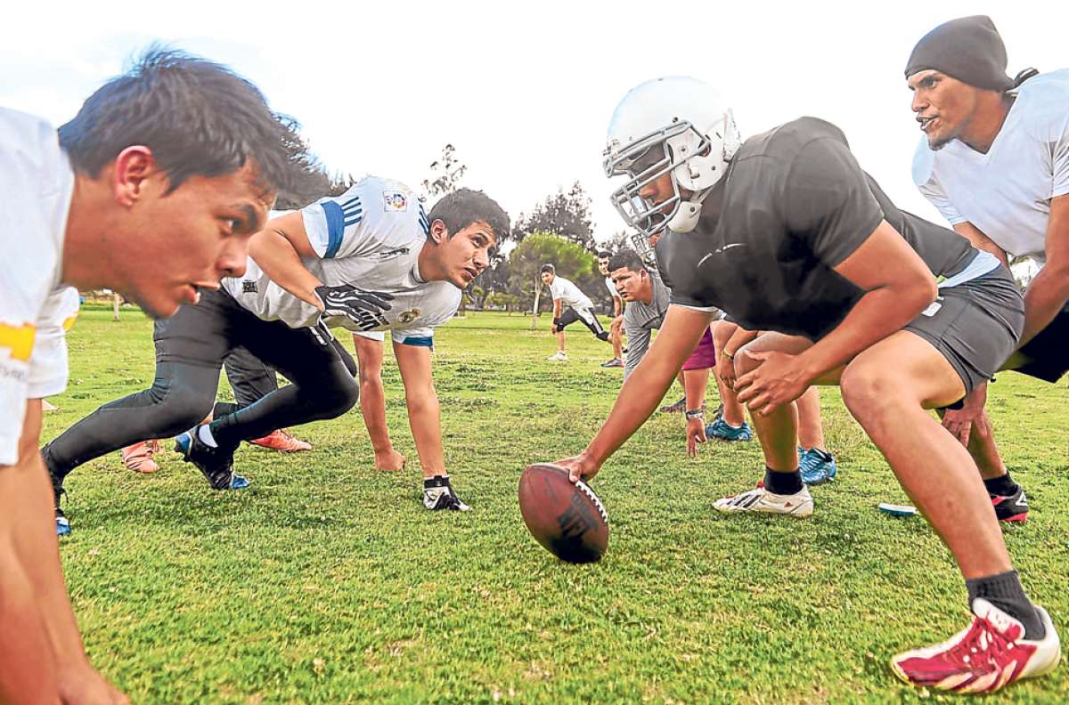 Javier Fierro (con el bal&oacute;n), espera las instrucciones de su mariscal de campo Jhonatan Tello (derecha), para iniciar la jugada durante un entrenamiento del equipo Quito Berserkers en el Parque Bicentenario. Foto: Carina Acosta / El Tel&eacute;grafo