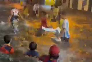 Niñas y niños jugaron en una calle inundada por la lluvia en Guayaquil