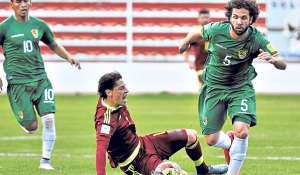 Mario Rond&oacute;n, de Venezuela, desde el piso intenta detener al volante boliviano Fernando Marteli, en el juego del pasado jueves en La Paz. AFP