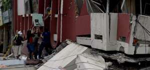 En las calles 9 de Octubre y Ricaurte, en Portoviejo, Milton Obando trata de rescatar sus m&aacute;quinas de coser.