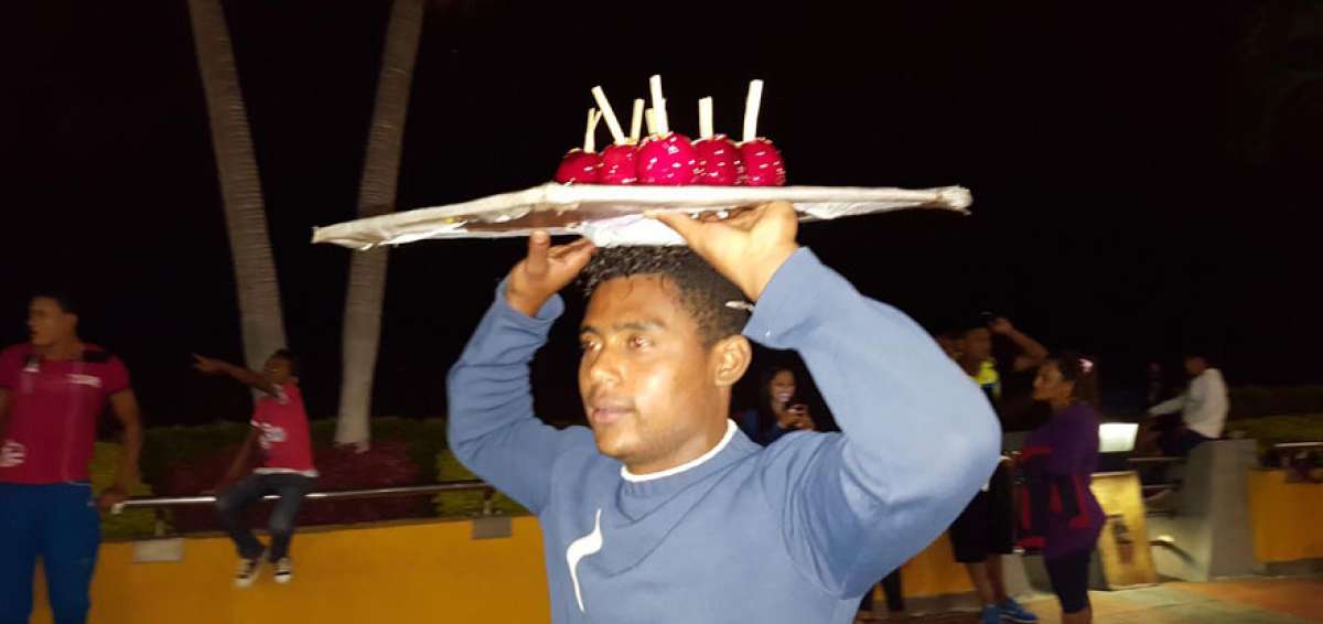 &ldquo;Chicho&rdquo; lleva en su cabeza las manzanas que ofrece los fines de semana en el malec&oacute;n Sim&oacute;n Bol&iacute;var.