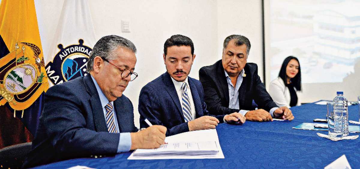 Luis Mancilla, gerente de Agunsa, firma el contrato. Lo observan el gerente de APM y el ministro de Obras P&uacute;blicas.