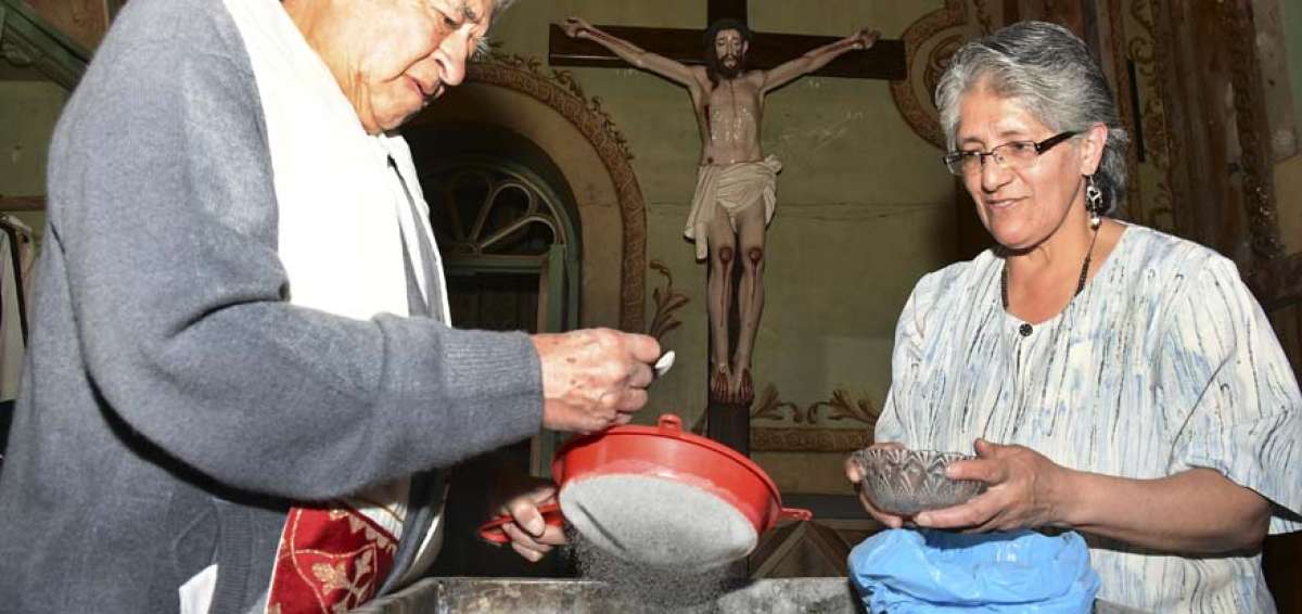 El padre Manuel Celi prepara la ceniza para marcar la frente de los fieles en la iglesia de Santo Domingo (Cuenca).