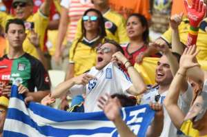Un grupo de hinchas griegos celebra la clasificaci&oacute;n de su selecci&oacute;n en las gradas del estadio Castelao. Foto: AFP.