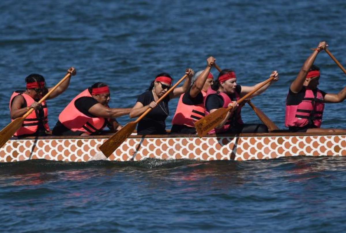 Mujeres sobrevivientes de cáncer de mama participan en la celebración del Día del Bote del Dragón.