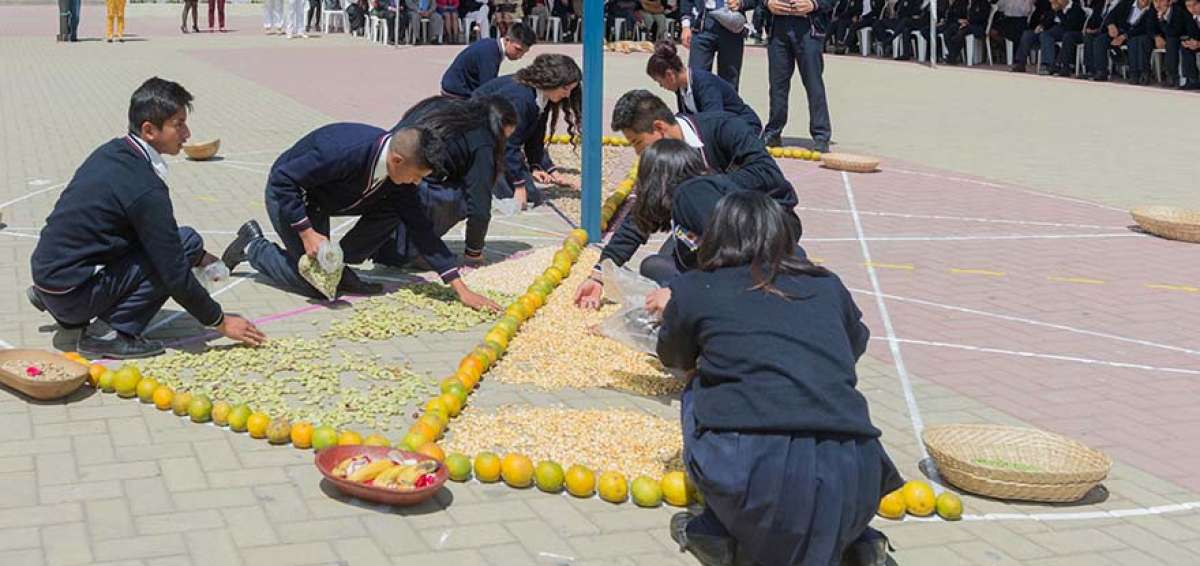 Estudiantes del colegio r&eacute;plica Mont&uacute;far formaron una chacana (cruz andina) con varias frutas y flores como parte de la presentaci&oacute;n del anuario. 