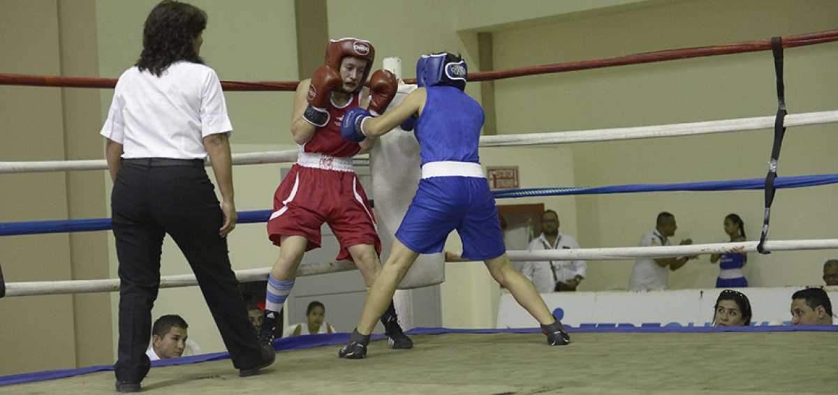 Nahomi Barzola (rojo), con el rostro ensangrentado, se defiende de los golpes de Dayanna Murillo en la final de los 52 kg; ambas deportistas son ecuatorianas.