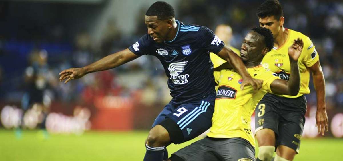 Caicedo (amarillo) disputa el bal&oacute;n con Bryan Angulo de Emelec. 