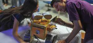 Ambos menores observan el robot que fue creado por Emily Ulloa luego de la charla que ofrecieron a inicios de la presente semana en Manta.