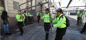 Polic&iacute;as desmontan este lunes 14 de octubre una barrera en una calle aleda&ntilde;a al Palacio de Gobierno ecuatoriano (Carondelet), en Quito. 