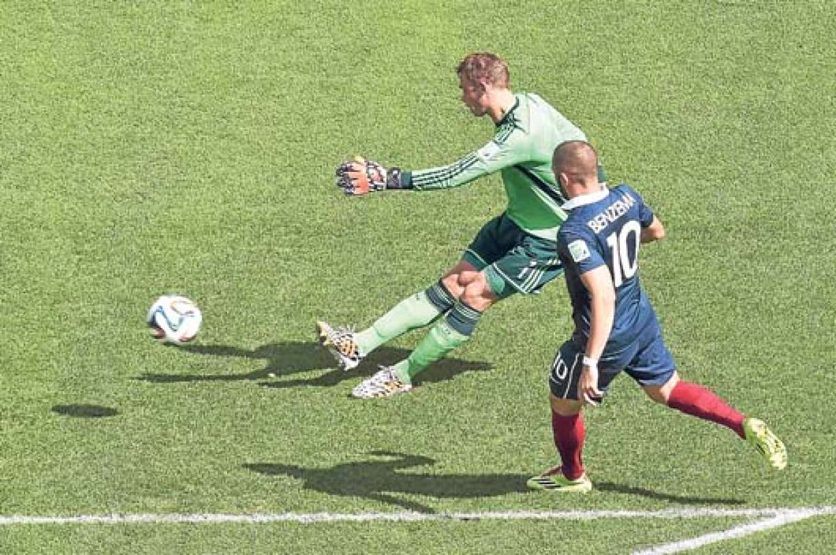 Manuel Neuer despeja un bal&oacute;n ante la presi&oacute;n del delantero Karim Benzema durante el partido del viernes pasado, entre Alemania y Francia. Foto: AFP.