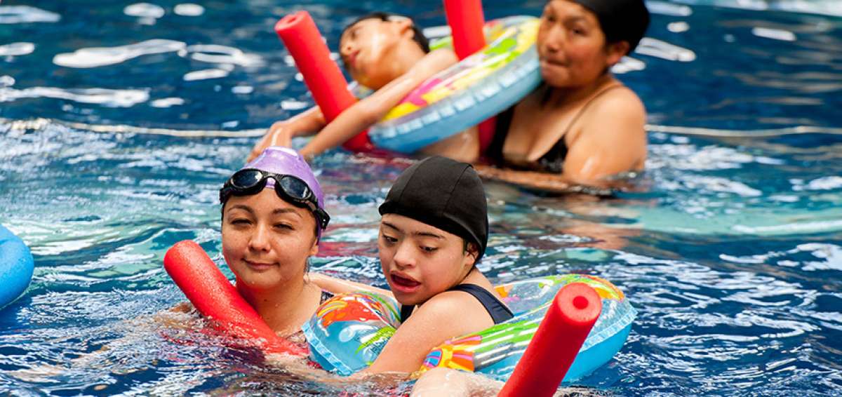 Pamela Enr&iacute;quez (i) en la piscina junto a sus alumnos; esta es una de las terapias que ofrece la fundaci&oacute;n Virgen de La Merced, ubicada en Sangolqu&iacute;.