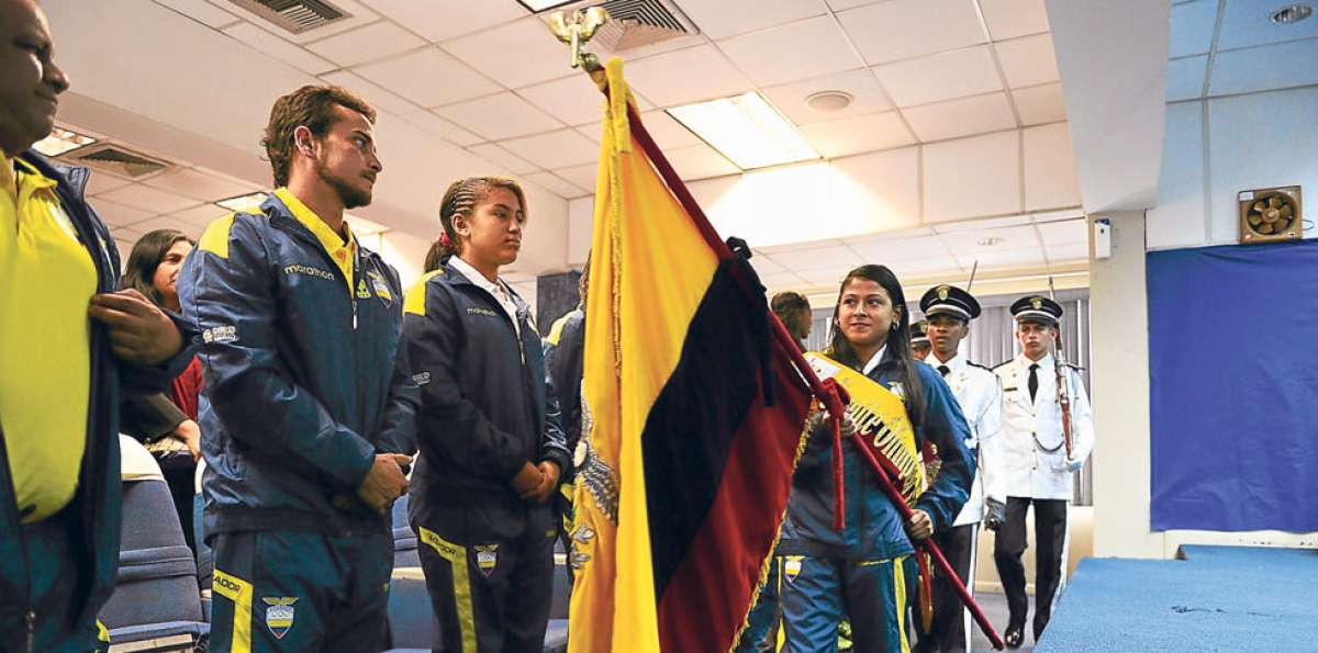 La abanderada Pamela Quishpe (der.) cobija al  entrenador David Gonz&aacute;lez y a la corredora Inara Cortez. Foto: Eduardo Escobar.