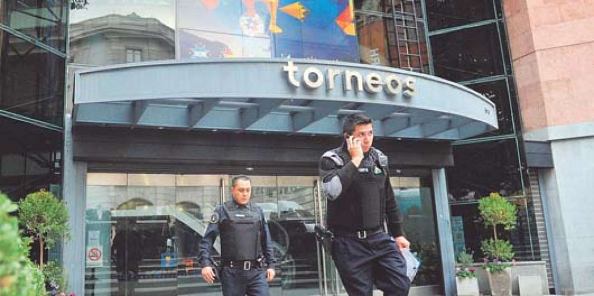 Dos polic&iacute;as salen de la sede de Torneos y Competencias; en ese edificio tambi&eacute;n funciona la empresa Full Play. Foto: AFP