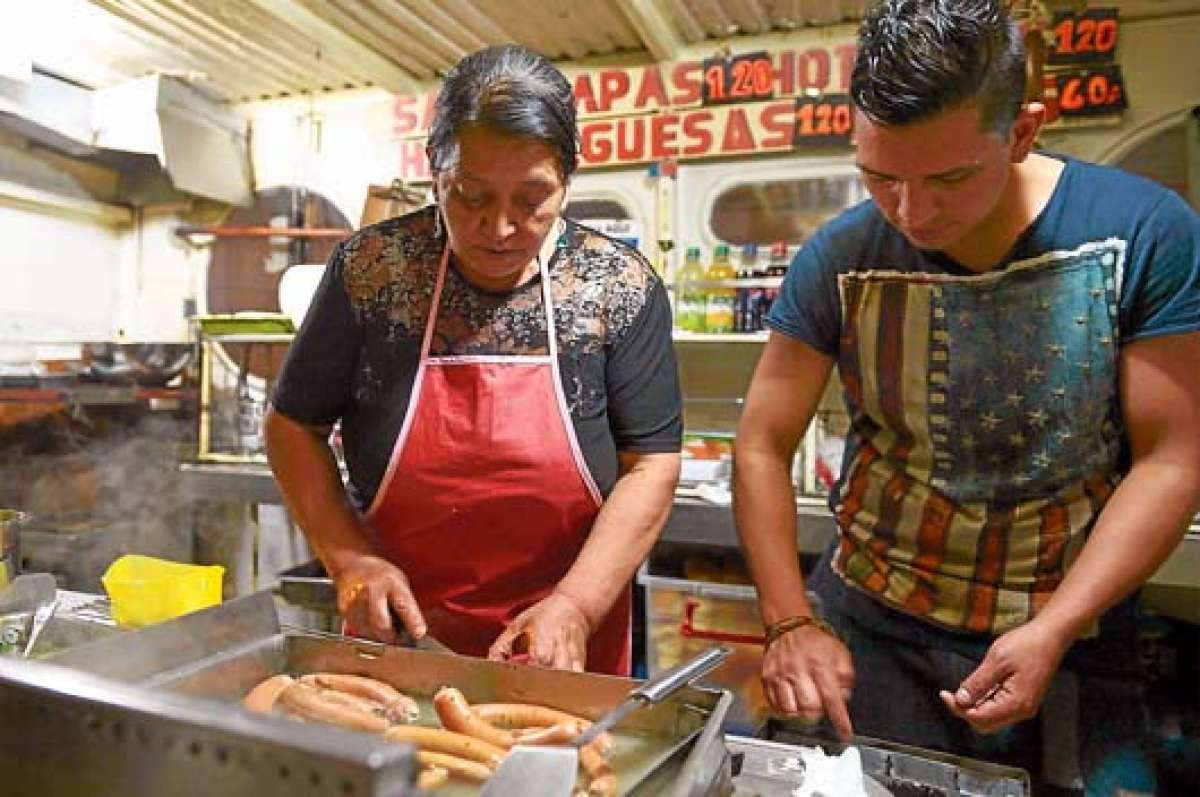 Las hamburguesas de don Mario son uno de los bocados m&aacute;s esperados por oficinistas y estudiantes en la esquina de las calles Sucre y Mart&iacute;nez. Foto: Roberto Ch&aacute;vez / El Tel&eacute;grafo