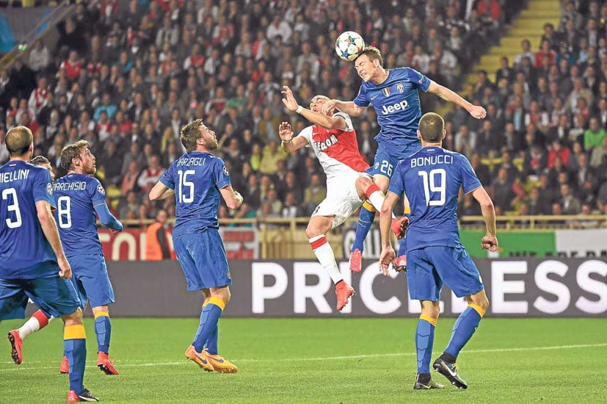 El lateral derecho Stephan Lichtsteiner rechaza la pelota con un fuerte cabezazo ante la marca del defensa del M&oacute;naco, Layvin Kurzawa. Foto: AFP