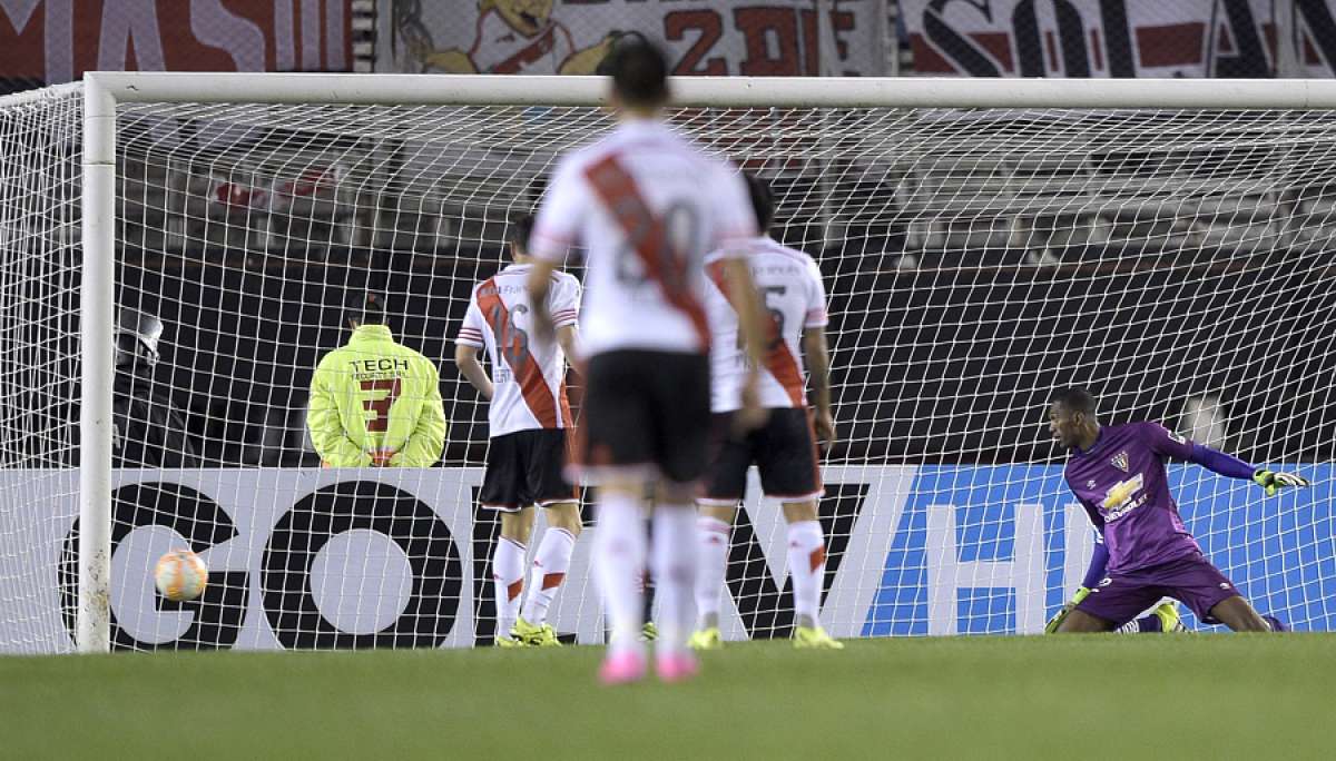 El golero de Liga, Alex&aacute;nder Dom&iacute;nguez (d), observa el bal&oacute;n en el primer tanto de River, de Lucas Alario. Foto: AFP