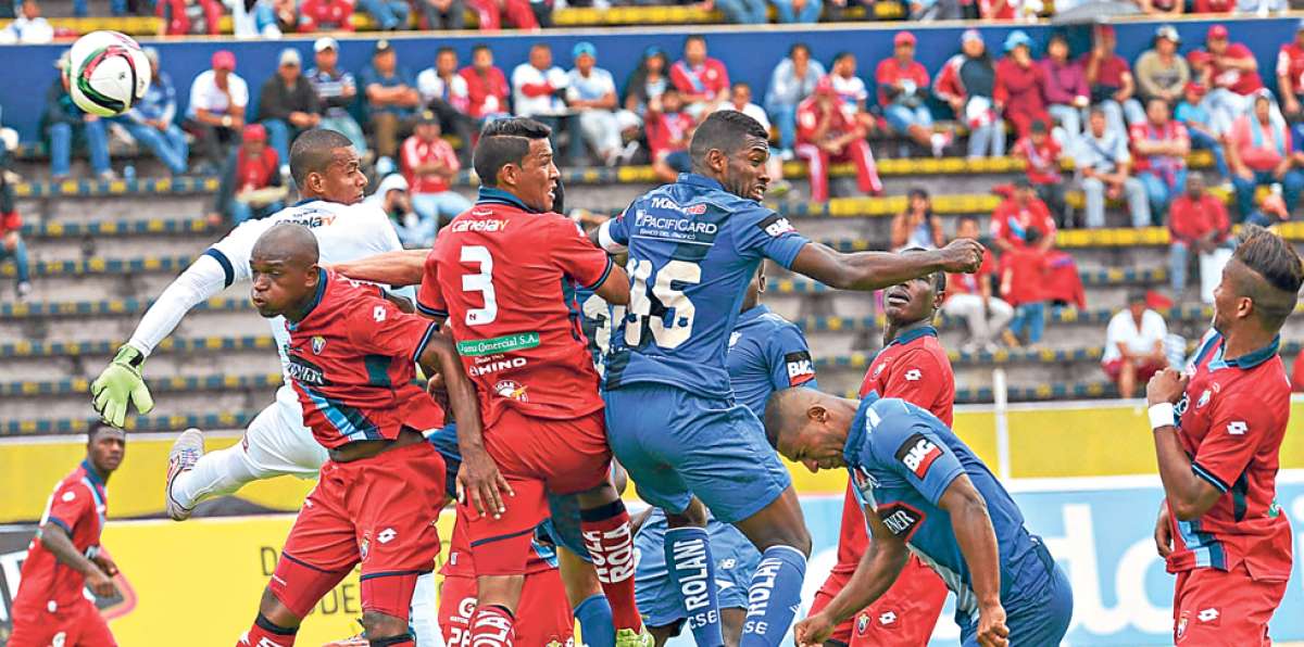 Gabriel Achilier (45) y Luis Luna (3) disputan un bal&oacute;n a&eacute;reo durante el encuentro de ayer en Quito.