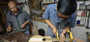 Los artesanos Luis Enrique y Pablo Andr&eacute;s Uyaguari trabajan juntos en el taller de guitarras, ubicado en las calles Arqu&iacute;medes y Abelardo Andrade.