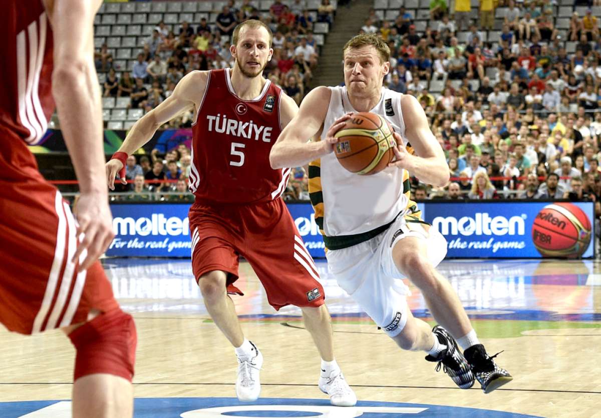 El lituano Martynas Pocius (der.) domina la pelota ante la marca de dos jugadores de Turqu&iacute;a.  Foto: AFP.