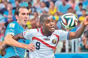 El delantero Joel Campbell (9) se llev&oacute; el protagonismo del  partido. Intenta superar la marca del uruguayo Diego God&iacute;n. Foto: AFP.