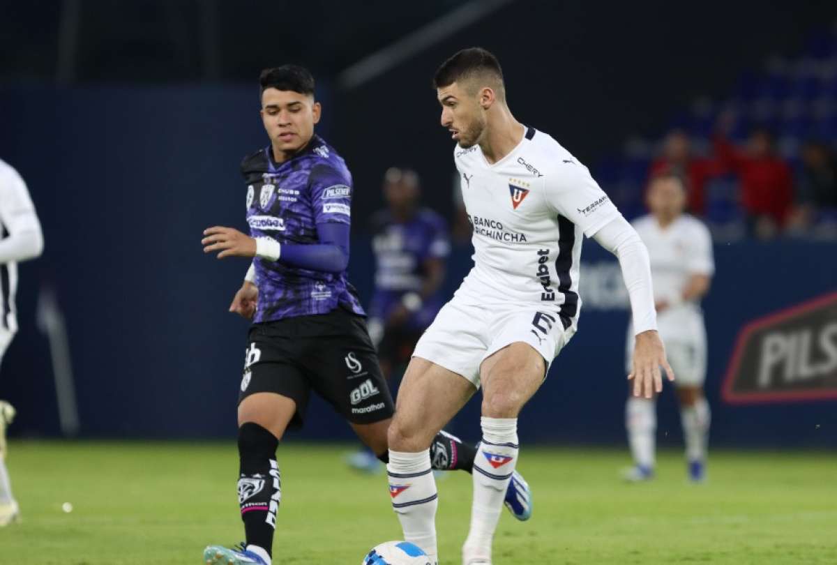 Facundo Rodríguez (der.) defiende el balón ante la marca del volante Kendry Páez.