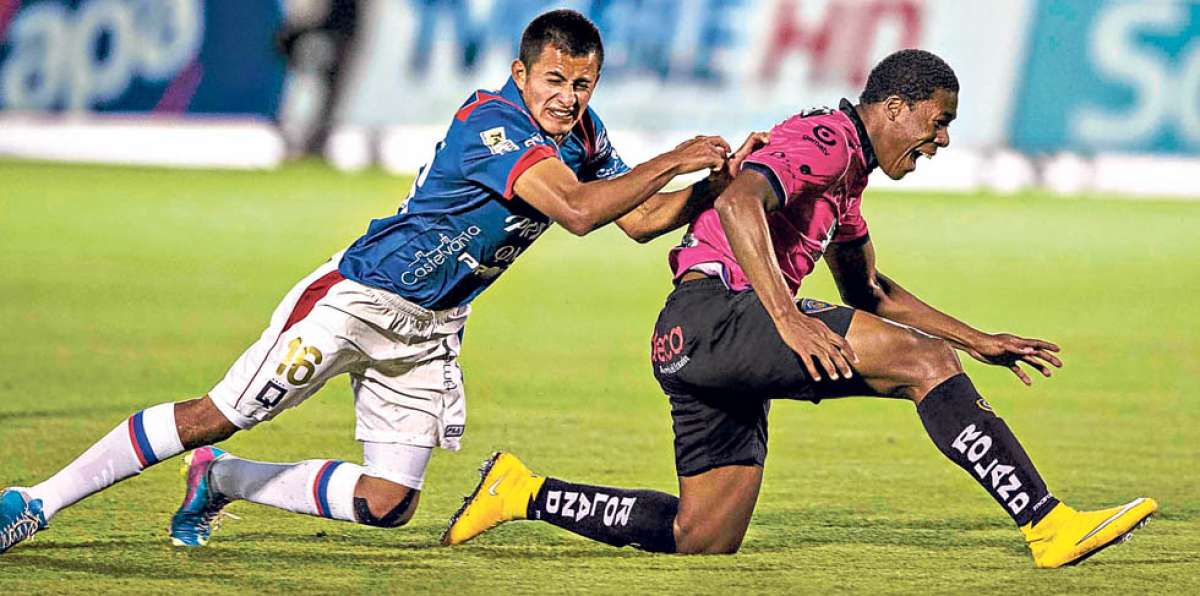 El defensa de Deportivo Quito, Michel Castro (i), disputa el bal&oacute;n con Daniel Angulo, de Independiente. Foto: Marco Salgado.